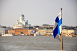Suomen lippu merellä, taustalla suurkirkko.